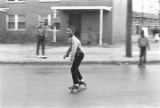 Boy skating in the street in front of a public housing project on Smythe Curve in Montgomery, Alabama, during Christmas vacation.