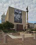 A giant mural by local artist Doug Leunig called "Abraham Blue," captured in 2019 during its temporary two-year display, looks down upon the city's Civil War Memorial also known as the Soldiers and Sailors Monument in Peoria, Illinois. The painting depicts martyred U.S. president Abraham Lincoln, who presided over the nation during that war in the 1860s. The artist says the name and blue tint reflect the president's frequent melancholy and depression during the bloody conflict