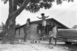 Elizabeth Ellis and Diane Foster playing on a make-shift seesaw in the dirt yard in front of a brick house in Newtown, a neighborhood in Montgomery, Alabama.