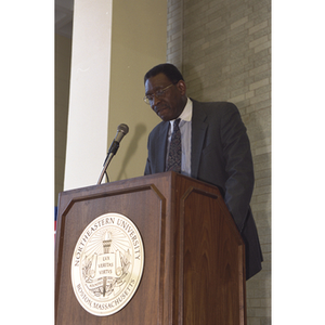 Unidentified man speaking at podium