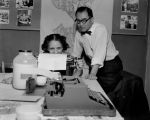 Asian-American man with typist proofreading correspondence, ca. 1950's