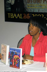 Roslyn Story holding up two of her books