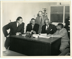 Group of men in office looking at document