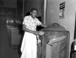 African-American cook putting songs on the jukebox at the Evergreen Cafe, 2309 1st Ave., Seattle, ca. 1952