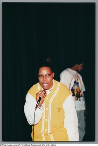 Photograph of a woman leaning towards the camera and rapping