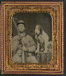 [Unidentified soldier in Confederate uniform with shotgun sitting next to dog]