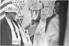 Klansmen carrying signs and flags in a parade during a Ku Klux Klan rally in Montgomery, Alabama.