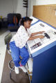 Eight-year-old Monica Bland working on the paste-up for the "Kids" page of the Tuskegee News at the newspaper's office in Tuskegee, Alabama.