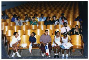 Children and Adults Sitting in Auditorium During Health Fair