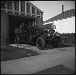 Three firefighters sitting in Oakland fire truck parked in driveway of fire engine no. 22