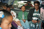 Reggie Crowder sitting in the backseat of a limousine with other children, Los Angeles