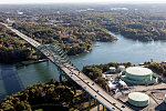 An October 2017 aerial view of the historic seaport of Portsmouth, New Hampshire, the largest city along the shortest coastline (18 miles) of any U.S. state. The focus is on the Piscataqua River Bridge, a through arch bridge that crosses the Piscataqua River, connecting Portsmouth with Kittery, Maine