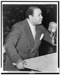 [Benjamin J. Davis, half-length portrait, facing right, standing at microphone, speaking at Negro Freedom Rally, Madison Square Garden, New York City]