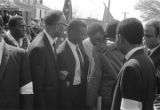 Fred Shuttlesworth, Ralph Abernathy and others talking in the street at Martin Luther King, Jr.'s funeral.