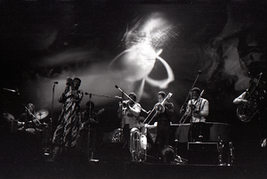 Taj Mahal in concert at Northfield, Mass.: Taj Mahal and horn section with light show behind