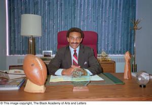 Photograph of Pettis Norman seated at his desk