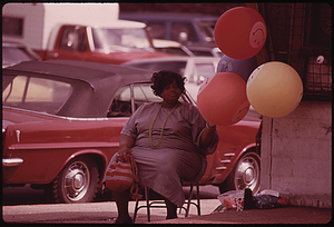 BLACK WOMAN SELLING GAS FILLED "HAVE A HAPPY DAY" BALLOONS ON A CHICAGO SOUTH SIDE STREET CORNER AT SOX PARK BASEBALL FIELD MANY OF THE CITY'S BLACK BUSINESS OWNERS STARTED WITH SMALL OPERATIONS SUCH AS THIS AND GREW BY WORKING HARD. TODAY CHICAGO IS BELIEVED TO BE THE BLACK BUSINESS CAPITAL OF THE UNITED STATES. BLACK ENTERPRISES MAGAZINE REPORTED IN 1973 THAT THE CITY HAD 14 OF THE TOP 100 BLACK OWNED BUSINESSES IN THE COUNTRY, ONE MORE THAN NEW YORK CITY