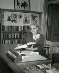 Susan Dart Bulter seated at Circulation desk, Dart Hall Branch Library