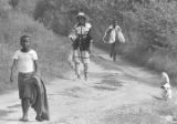 Woman, two boys, and a dog walking down a dirt road near Mount Meigs in Montgomery County, Alabama.