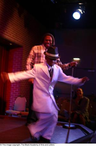 Boy in white suit and Curtis King on stage