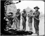 Indians pose with bows and arrows