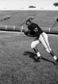 Larry Hubbard carries the football in his arms, 1959