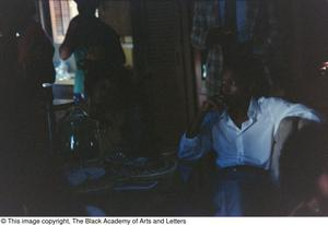 Photograph of a man sitting in a chair looking to the left and away from the camera