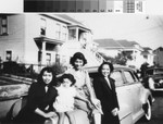 Three women and one child beside car on Harmon Street, 1950