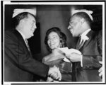 [Vice President-elect Hubert Humphrey shaking hands with Dr. King, as Mrs. King looks on, at a rally at Harlem's 369th Regiment Armory]