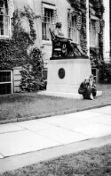 Two unidentified women sitting on the base of a statue