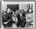 [Student demonstrators link arms while singing "We Shall Overcome" outside the U.S. Consulate in Toronto, Canada]