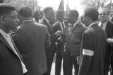 Fred Shuttlesworth, Ralph Abernathy and others talking in the street at Martin Luther King, Jr.'s funeral.