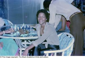 Photograph shot of Juanita Simmons smiling while sitting in a chair