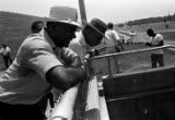 Martin Luther King, Jr., and another man, standing at a fence at the bottom of a hill during the "March Against Fear" through Mississippi, begun by James Meredith.