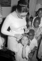 Amy Peppler, matron of honor from the wedding of Freddie and Susie Sanders Hubbard, putting flowers in a her daughter Robin's hair during the reception at the home of the bride's parents in Montgomery, Alabama.