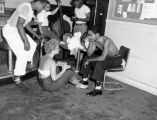 Unidentified jazz band socializing with a woman playing conga drums, August 2, 1952