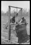 Negro farm owner and brother leaning on well top on their farm, near Jefferson, Texas