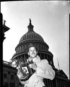 Robert Scurlock in front of U.S. Capitol, holding Speed Graphic camera : acetate film photonegative