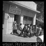 Teacher's aide greeting African American students at the door of a church converted into a "Freedom School" in San Bernardino, Calif