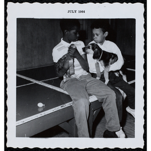 Two winners of the Boys' Club Pet Show sit together on a table with their pets