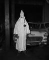 Man outside the Jefferson County courthouse in Birmingham, Alabama, posing in a Ku Klux Klan robe and hood that was confiscated after the arrest of Klan members.