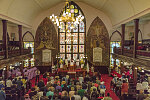 A trumpeter plays and the choir sings and claps during a service at the Emanuel African Methodist Episcopal Church in Charleston, South Carolina, in April of 2017, ten months after a notorious mass murder during a prayer service there