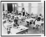 Teacher Alice O'Donnell gives assistance to a pupil in her first grade class in one of the new mobile classrooms at the summer school in Chicago (715 South Kildare Avenue)