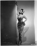 Thumbnail for Unidentified woman wearing evening dress posed with right arm extending up wall