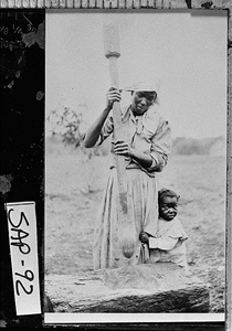 Photograph of woman hulling rice with mortar and pestle, Sapelo Island, McIntosh County, Georgia, between 1915 and 1934