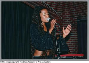 Soul artist Rhea singing into microphone