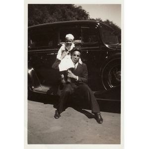 Child sits on the shoulder of a man in uniform