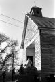 People entering a wooden church building in rural Prattville, Alabama, probably for a meeting of the Autauga County Voters Association.