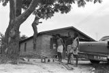 Elizabeth Ellis and Diane Foster playing on a make-shift seesaw in the dirt yard in front of a brick house in Newtown, a neighborhood in Montgomery, Alabama.