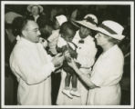 African-American child receiving typhoid vaccine from county health doctor and W.P.A. nurse